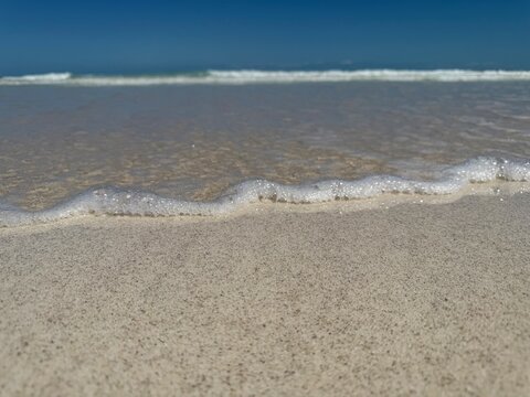 Close-up surface level view of ocean surf on a white sandy beach, El Cuyo, Yucatan, Mexico