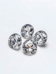 Four sparkling, round,  faceted gems on a white background