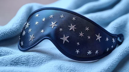Rolgordijnen Stylish navy blue sleep mask with silver stars rests on soft blanket © Iurii