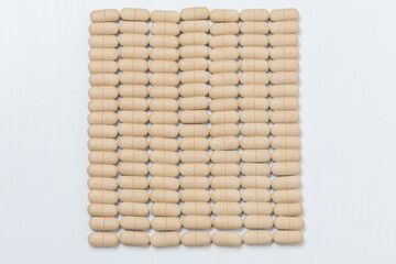 Oval brown pills as a dietary supplement on a white table