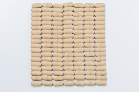 Oval brown pills as a dietary supplement on a white table