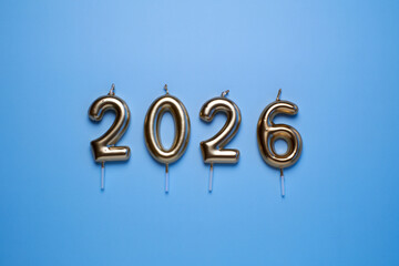 Golden candles spelling out the year 2026 on a blue background