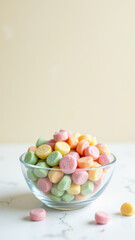 A clear glass bowl filled with vibrant multi-colored hard candies against a gradient background.
