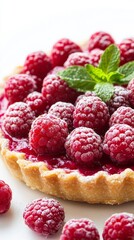 A beautifully crafted tart features a smooth raspberry filling topped with plump, fresh raspberries and a sprig of mint, radiating freshness. This tempting dessert is perfect for summer gatherings