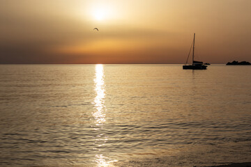 Sunset at the sea with a sailboat. Sardinia, Rena Majori beach.