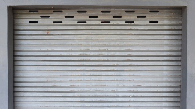 Rolling door. Steel shutter door of warehouse. The shutters are gray metal. Steel rolling shutter background. Silver metal rolling shutter background. Background images and texture images.