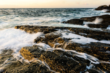 Exploring the rugged coastal landscapes of Sweden during a sunset at the shoreline
