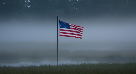 Fototapeta premium American flag waving gently on a foggy morning along the coast