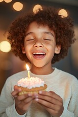 Naklejka premium Joyful Child Celebrating Birthday with Cupcake and Candle in a Warm Atmosphere