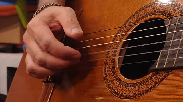 man playing arpeggio on classic guitar