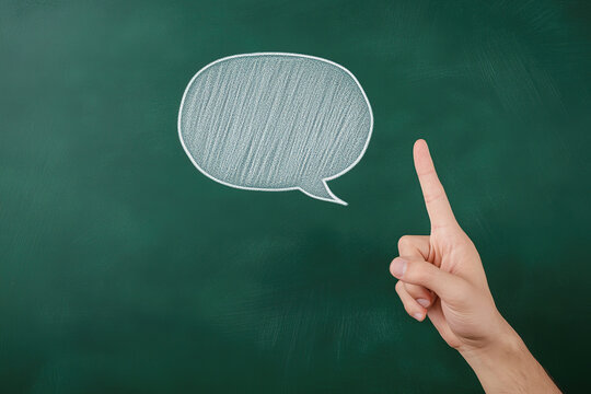 Hand pointing at a chalkboard speech bubble in a classroom setting