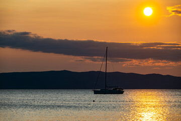 Sailboat passing in front of Cres island, Croatia with istrian peninsula rising in the background...