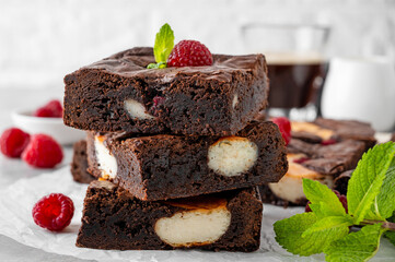 Cheesecake brownies with raspberry on a gray concrete background. Delicious dessert