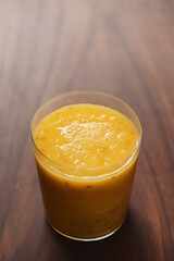 Mango lulo smoothie on walnut wood table with copy space