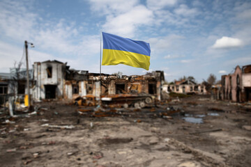 Ukrainian Flag in Front of War-Torn Ruins Under a Clear Sky