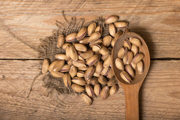 Pistachio nuts on a wooden trencher, natural and healthy snack concept