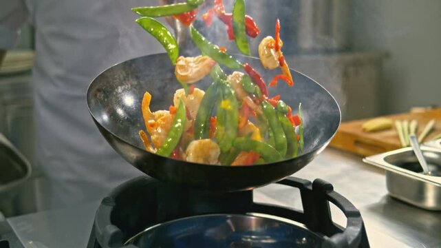 SLO MO DS Chef tossing the prawns and veggies frying in the hot wok