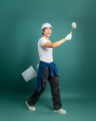 Enthusiastic painter ready to work, wearing safety gear and holding a paint roller and bucket,...