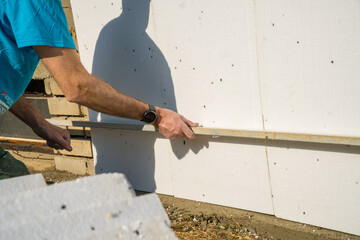 installing rigid styrofoam insulation board for energy saving of the house wall