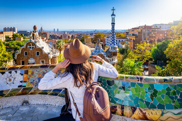 A tourist woman enjoys a sightseeing trip of the famous Park Güell in Barcelona, Spain, on a sunny day