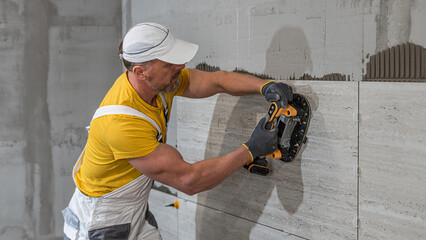 Tiling with large format tiles. A tiler expelling air from under the tile by a vibration suction...