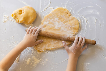 Children's hands knead the dough. Cooking with a child. Family baking..