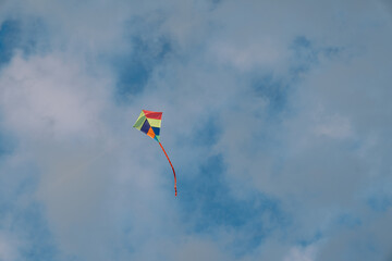Colorful kite soars in the cloudy sky
