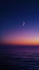 Crescent moon shining over calm sea at twilight with purple and blue gradient sky