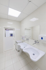 A pristine and immaculate restroom that features dual sinks, white tiles, and a sleek modern design aesthetic