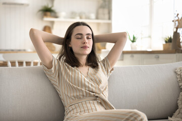 Chilling out. Serene carefree young woman enjoy good free summer day at home relax on sofa in laid...
