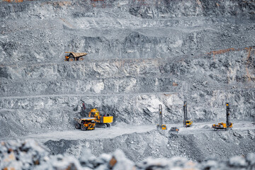 Work of heavy equipment big trucks in open pit mine.