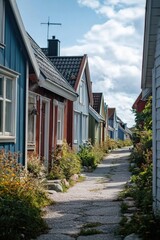 Colorful houses in a quaint village on a cloudy summer day. A rural countryside setting with gardens and paths.