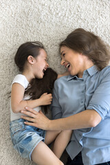 Cozy mess. Vertical top view excited active family millennial mother little daughter kid or two...