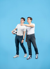 Two friends with a soccer ball look off into the distance. One points towards something interesting...