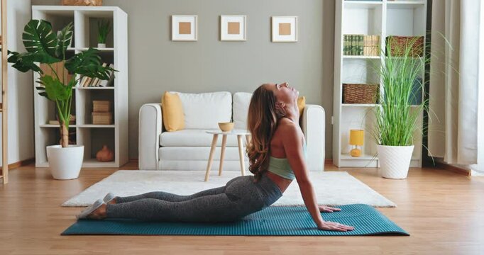 Fit woman practicing yoga at home enjoying her morning routine in a cozy living room