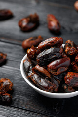 Dried sweet pitted dates in white bowl. Healthy food