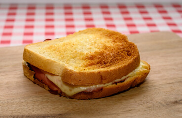 A perfectly toasted grilled cheese sandwich, golden and crispy, rests on a wooden board. The...