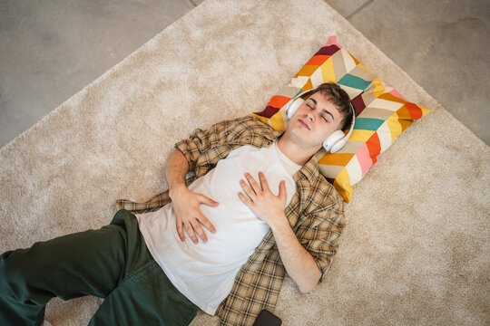 one young man use headphones for online guided meditation practice