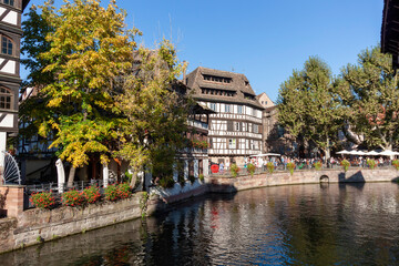 Naklejka premium A scenic view of Strasbourg, France, featuring traditional half-timbered houses lining a picturesque canal