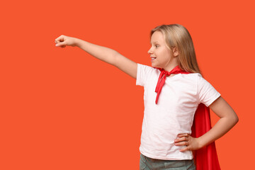 Cute teenage girl dressed as superhero on orange background