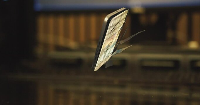 3D animation of dropped modern smartphone with cracked screen glass levitate in slow motion