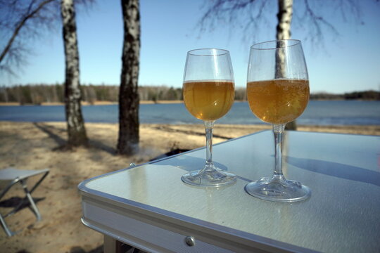 camping two plastic glasses with sparkling drink on the sand bea
