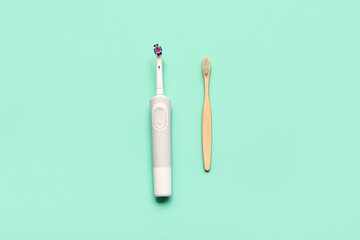 Electric and bamboo tooth brushes on turquoise background. Concept of evolution