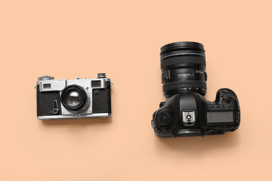 Retro and digital photo cameras on beige background. Concept of evolution