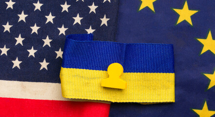 Fototapeta premium Ukrainian flag against the background of the sponsor's US flag