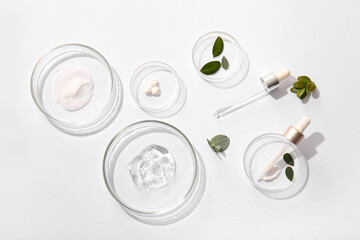 Petri dishes with samples of natural cosmetic products on light background