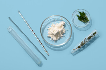 Petri dishes with sample of natural cosmetic product on light blue background