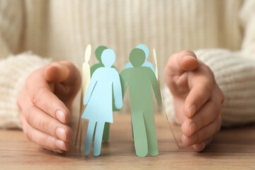 Woman with paper human figures at table, closeup