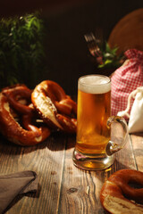 A mug with beer and traditional German bretzels in Bavarian rustic style	