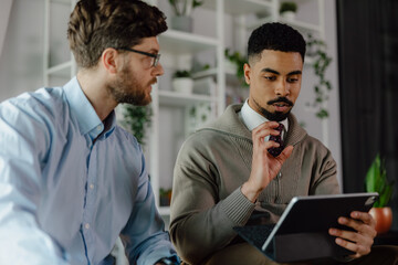 Two Professionals Collaborating on a Tablet in a Modern Office Setup